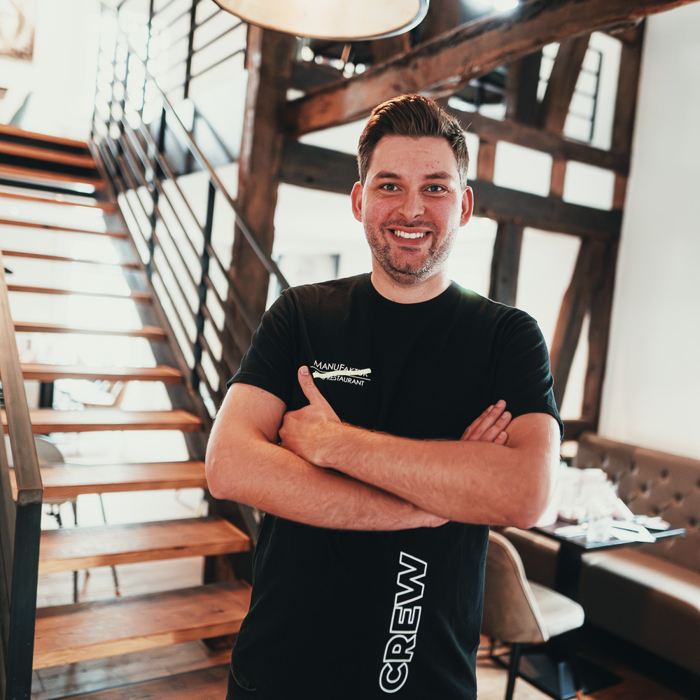 Ansprechpartner Robin Henze im ManuFaktur-Crew-Shirt im Restaurant