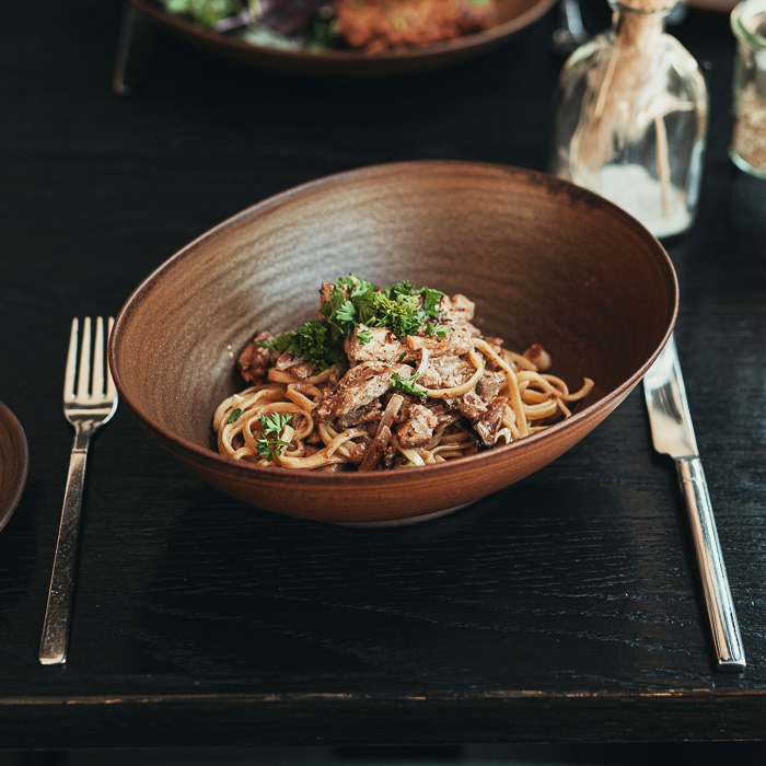 Tagliatelle mit Rindergeschnetzeltem und Petersilie in einer Steingutschale